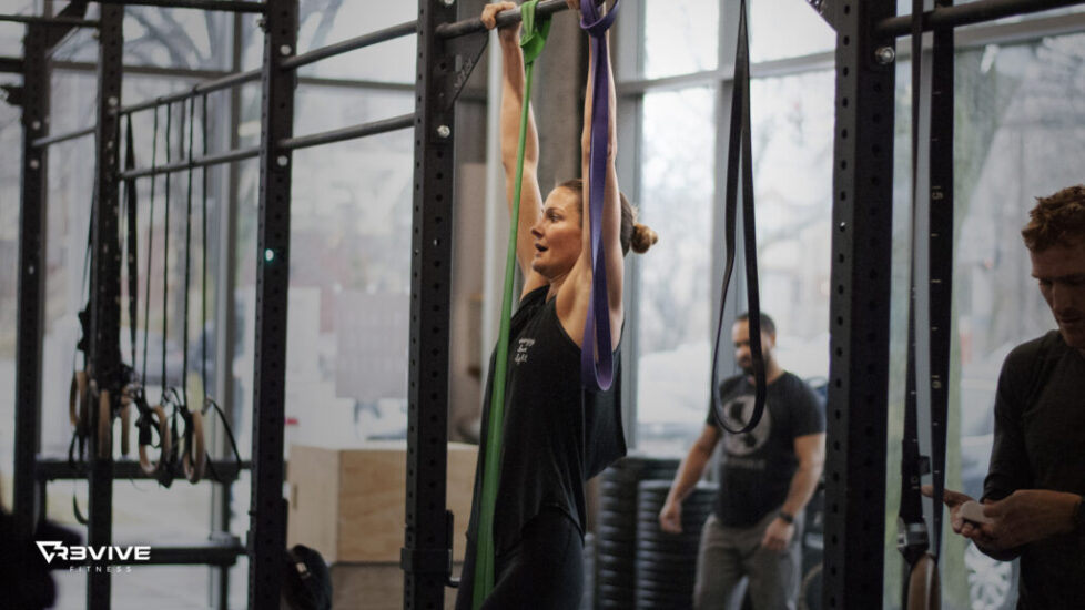 A woman working on pull-ups using bands.